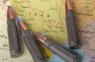Four rifle cartridges arranged on a map of Iran, Afghanistan, and Pakistan, symbolizing regional conflict.