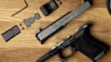 Glock 19 Gen 6 pistol field-stripped on a wood surface, with slide, frame, MOS adapter plate, red dot optic, mounting screws, and hex wrench laid out. Slide is stamped "Glock 19 Gen 6 / 9x19 / Austria.